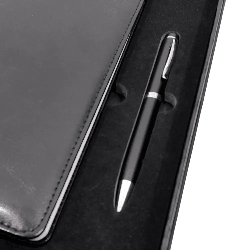 Close-up of black pen and leather-style notebook in foam-lined gift box, perfect for professional gifting.