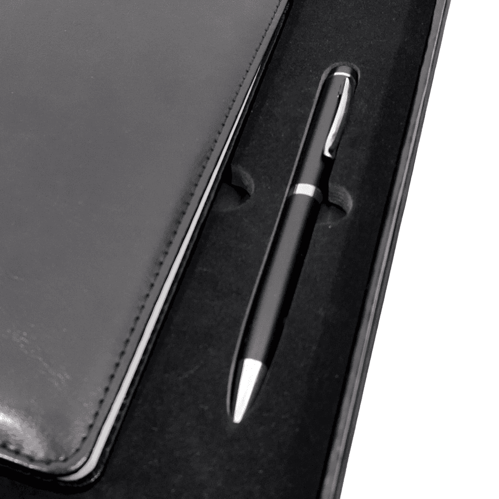 Close-up of black pen and leather-style notebook in foam-lined gift box, perfect for professional gifting.