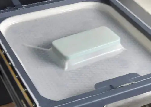Close-up of the ST-3042 heat press machine's vacuum chamber sealing a phone case mold during the sublimation process.