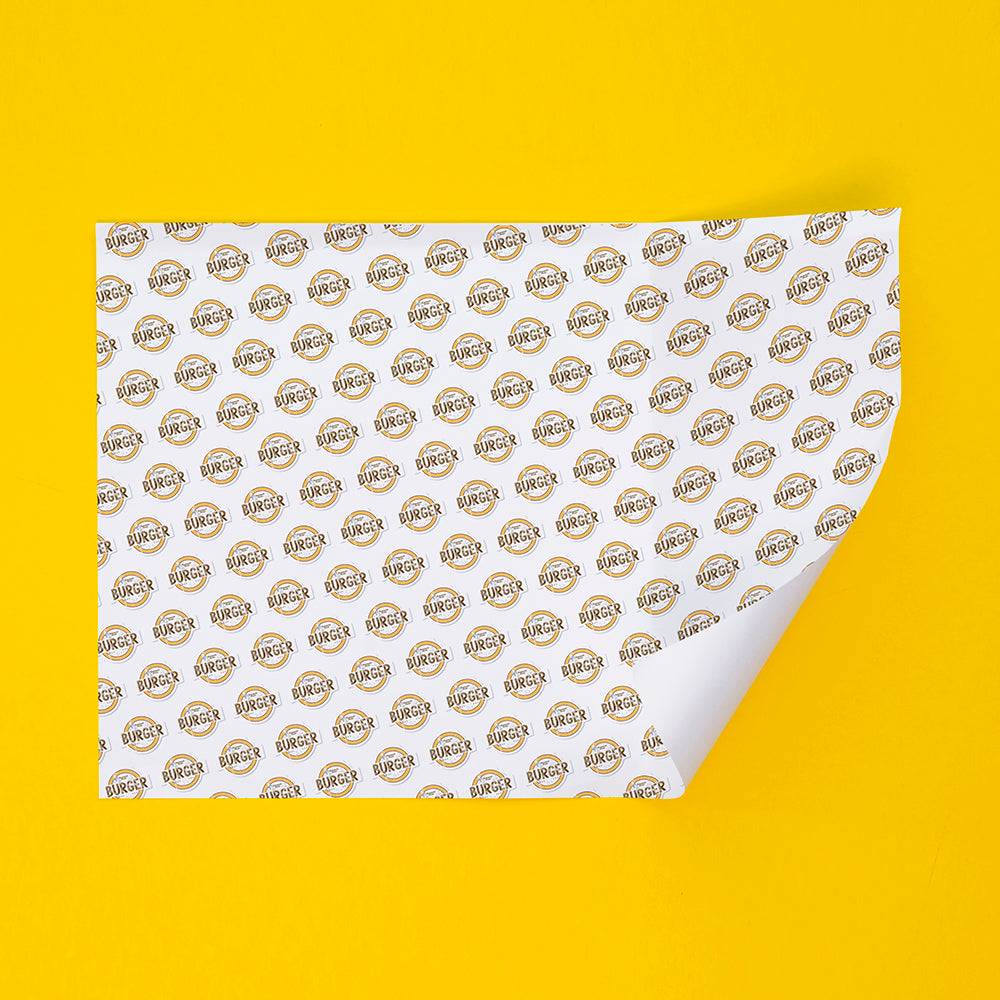 Durable sandwich paper featuring a repeating burger logo pattern, perfect for eco-friendly food wrapping in industrial take-out settings.