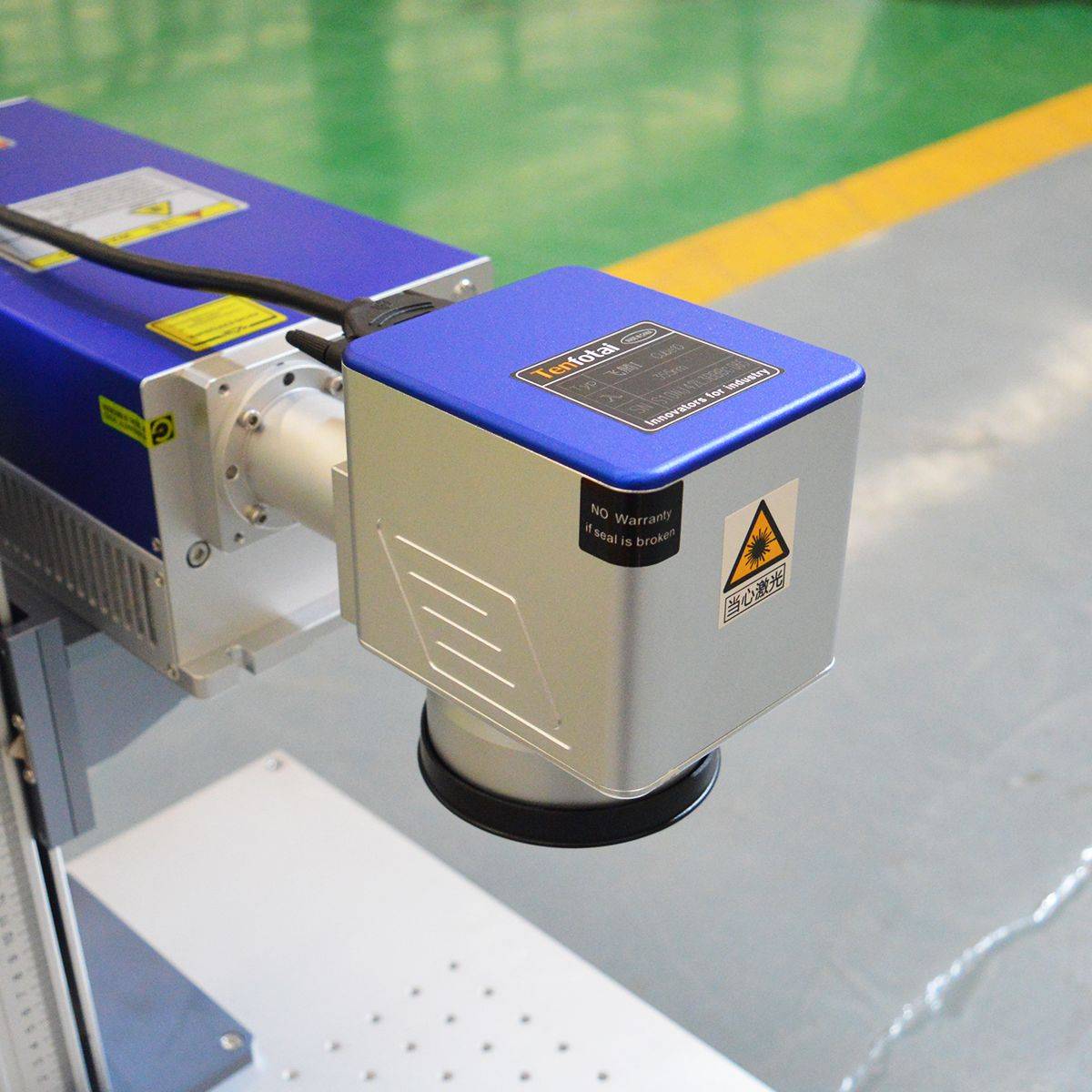 Close-up of avalaser UV laser head with safety warning labels, showcasing the precision optics used for fine engraving on various materials.